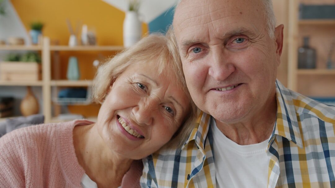 Happy senior couple smiling together at home holding a membership card